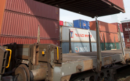 Ein Güterzug wird mit Containern beladen.